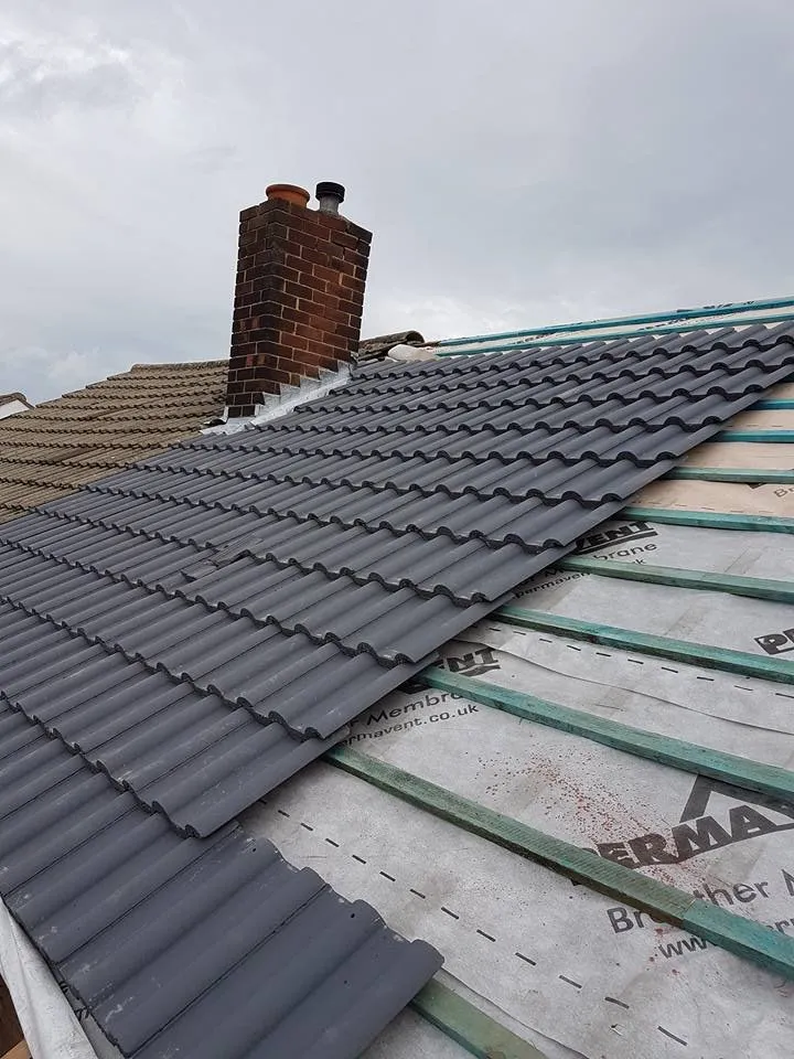 Roofer replacing broken tiles on a Birmingham terraced house